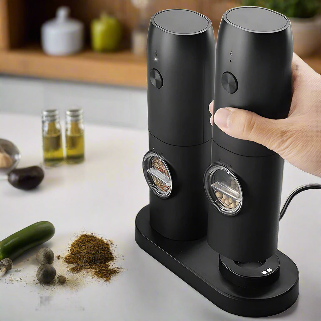 Black pepper grinder set with charging base and accessories on a blurred background